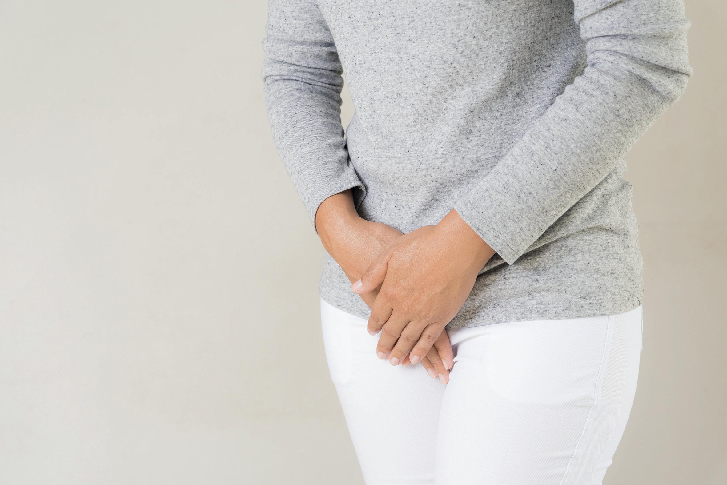 Frau hält sich den Unterbauch